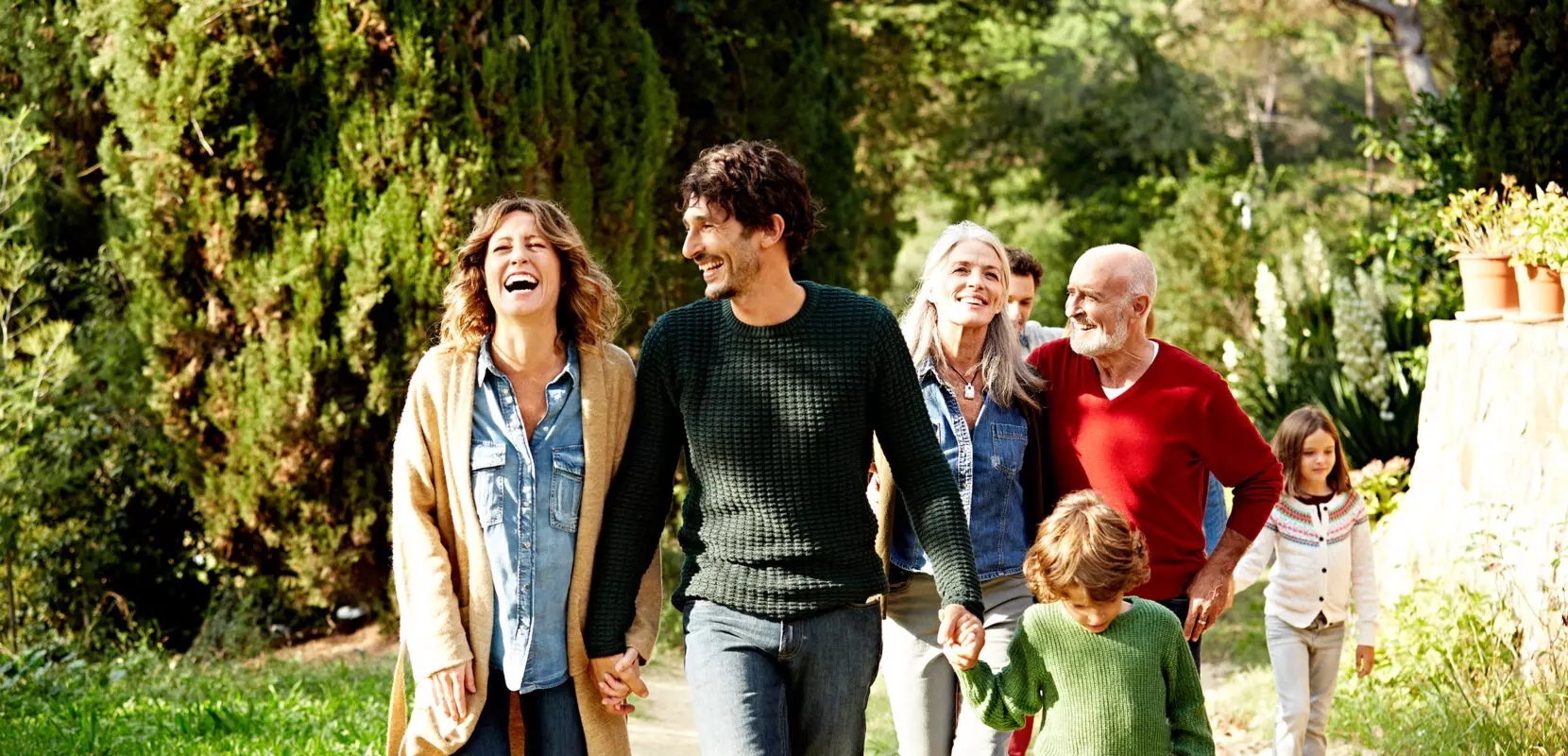 multigenerational family smiling and walking through the woods